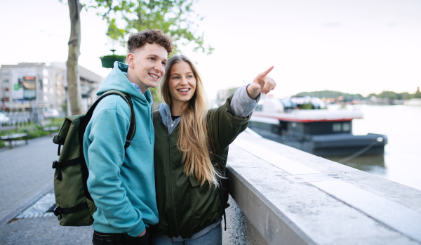 A happy young couple travelers in city on holiday, sightseeing.