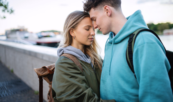 A happy young couple travelers in love in city on holiday, hugging.