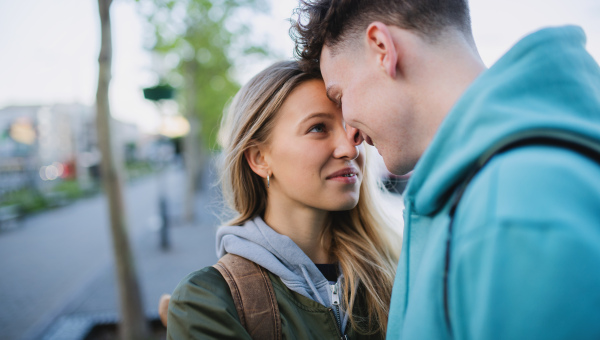 A happy young couple travelers in love in city on holiday, hugging.