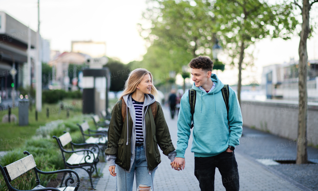 A happy young couple travelers in city on holiday, walking and talking.