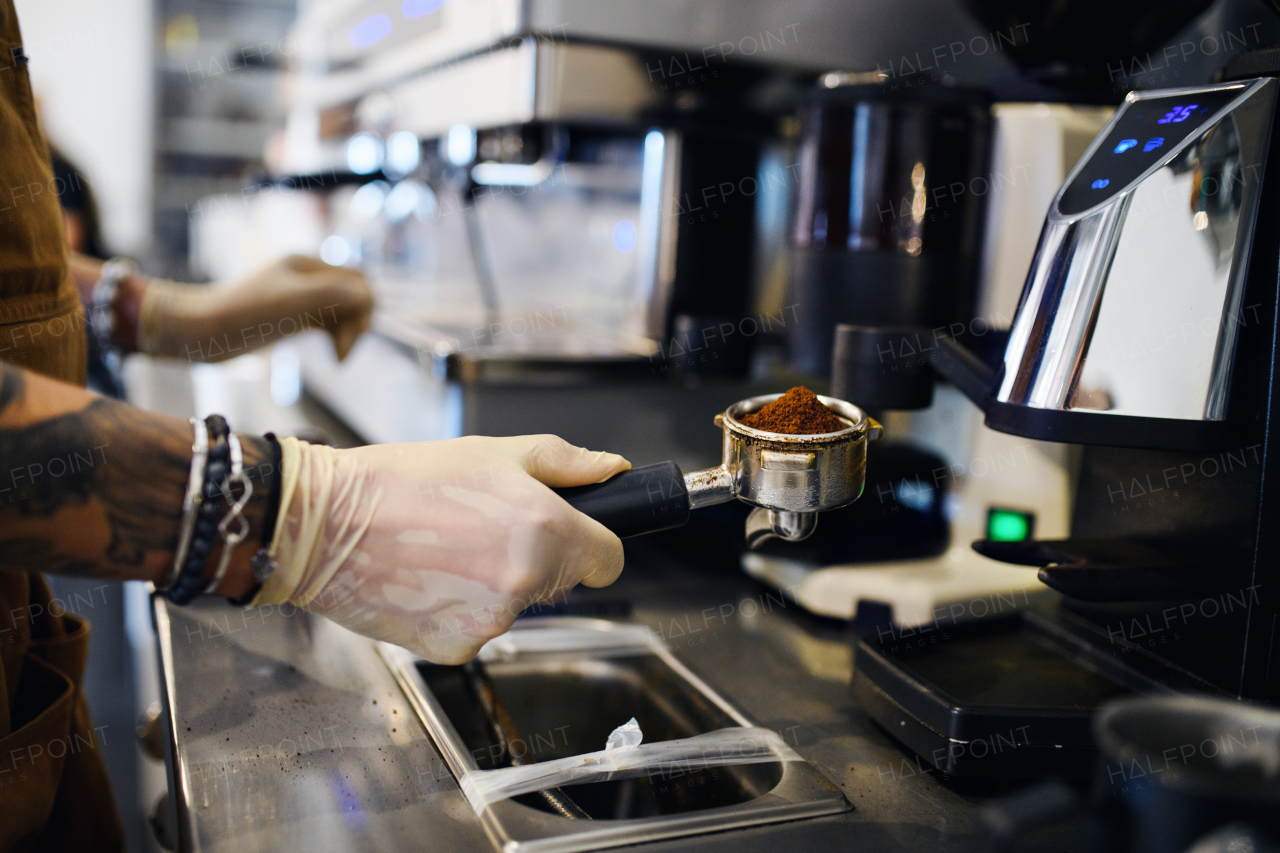 Unrecognizable barista working with gloves, coffee shop open after lockdown quarantine.