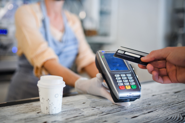 Contactless payment with debit card, coffee shop open after lockdown. Midsection.