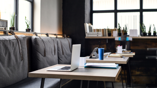 Laptops on desks in empty modern office, business concept.