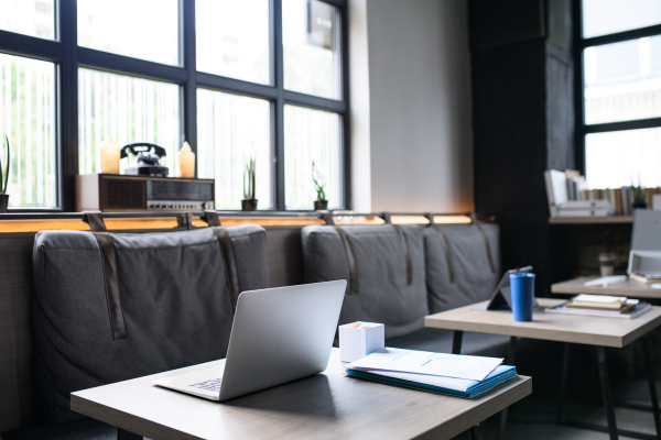 Laptops on desks in empty modern office, business concept.