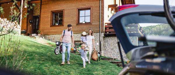 Family with two small children going on cycling trip by car in countryside.