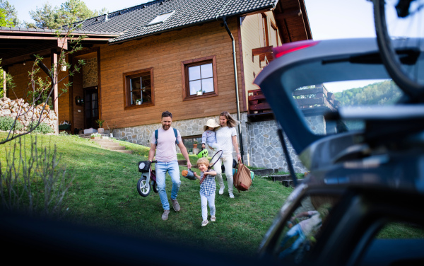 Family with two small children going on cycling trip by car in countryside.