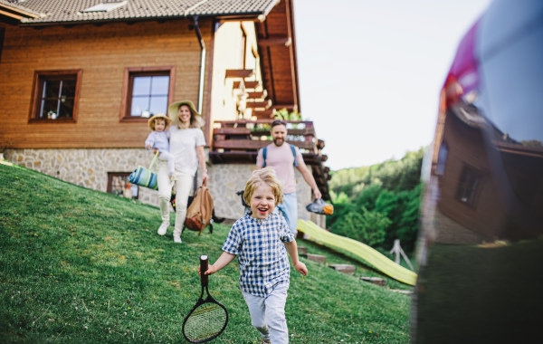 Family with two small children going on trip by car in countryside.