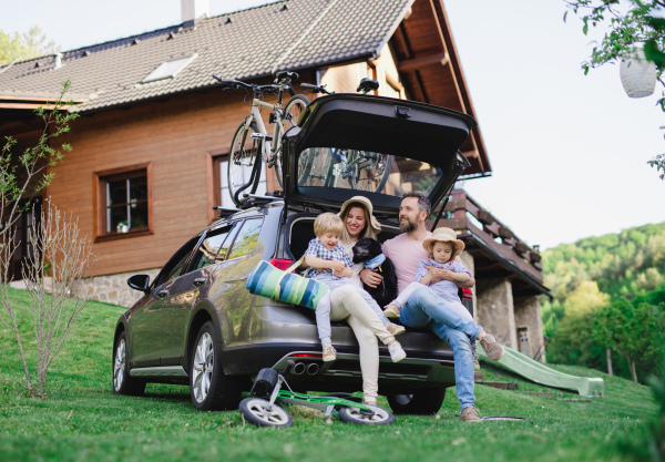 Family with two small children and dog going on cycling trip by car in countryside.