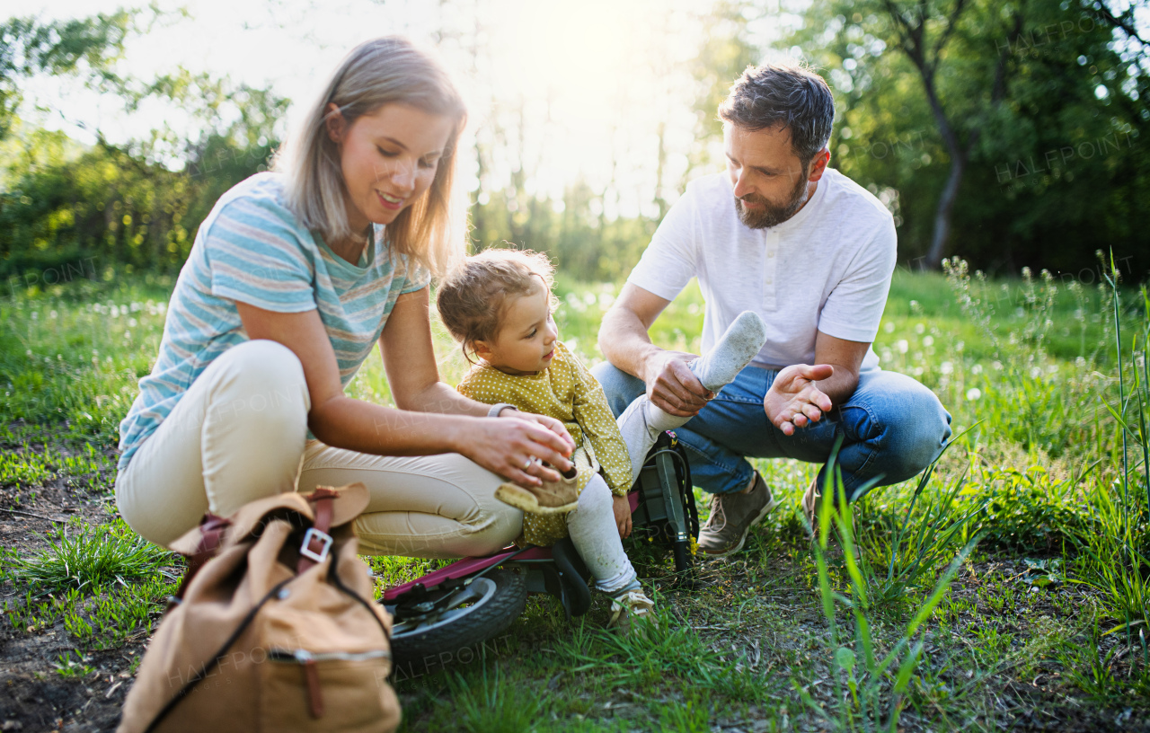 Family with small daughter resting on cycling trip, taking a break.