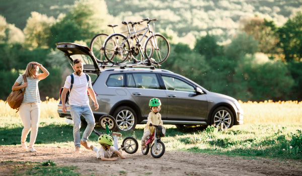 Family with two small children going on cycling trip by car in countryside.