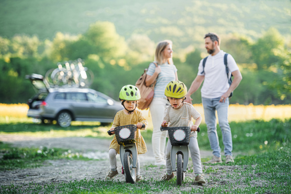 Family with two small children going on cycling trip by car in countryside.