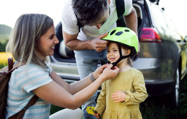 Happy family with small child going on cycling trip in countryside.