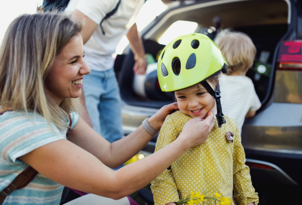 Family with two small children going on cycling trip by car in countryside.