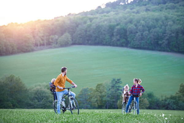 Family with two small children on cycling trip in nature, having fun.