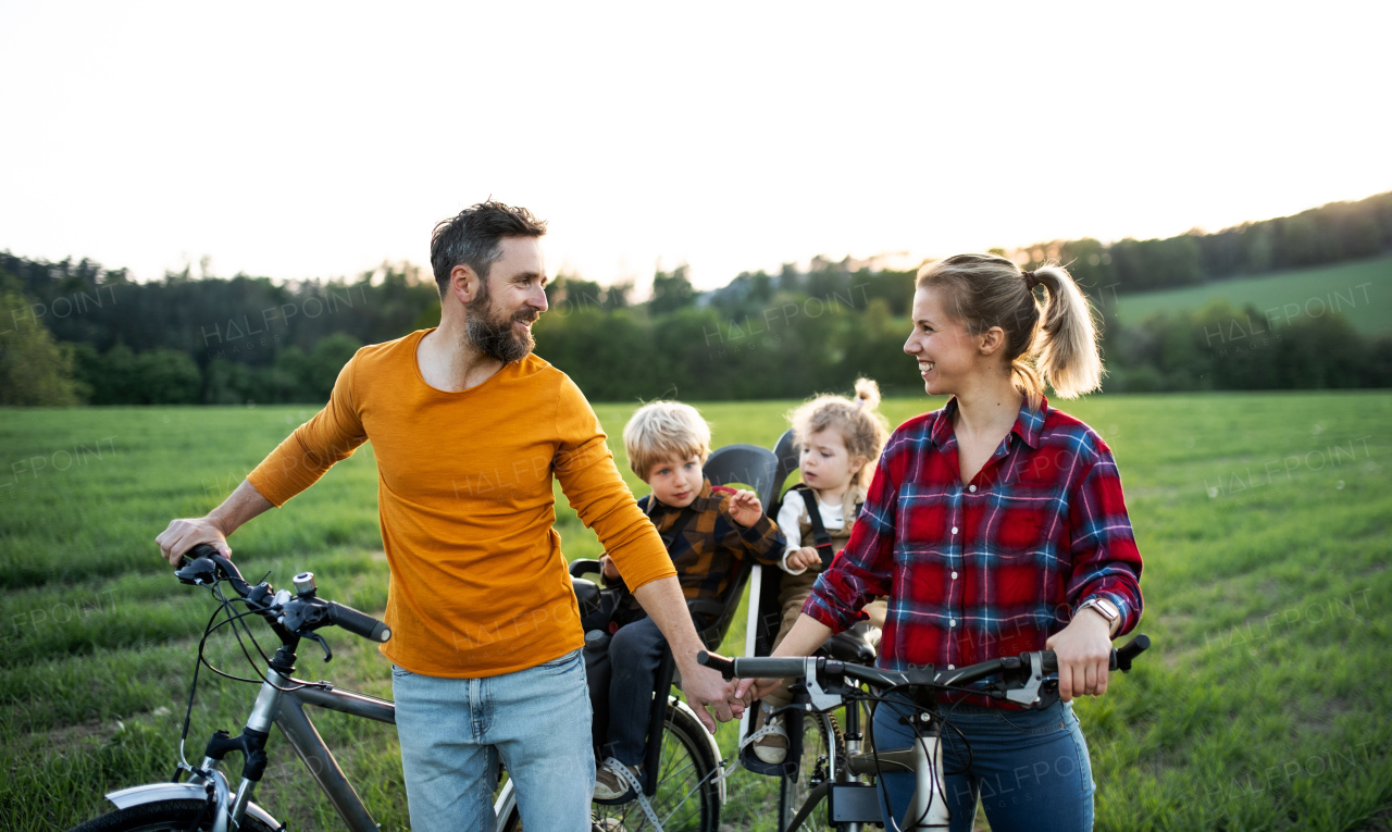 Family with two small children on cycling trip in nature, resting.