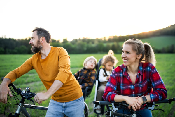 Family with two small children on cycling trip in nature, having fun.