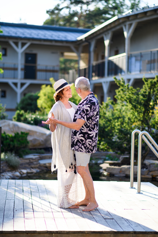 Senior couple dancing outdoors on holiday, having fun. Back to normal concept.