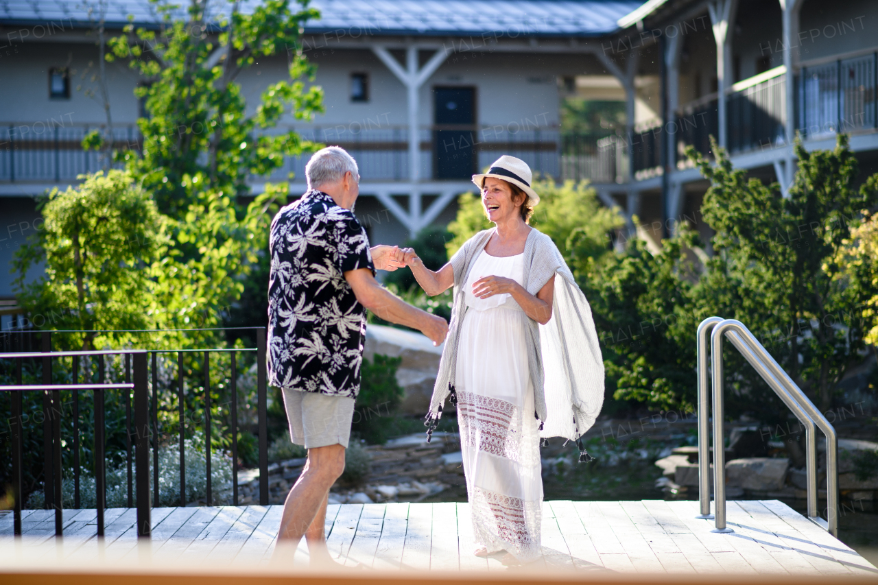 Senior couple dancing outdoors on holiday, having fun. Back to normal concept.