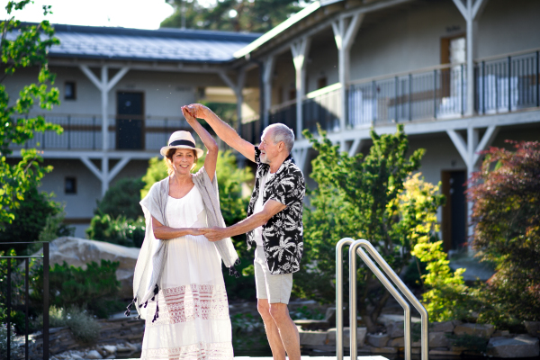 Senior couple dancing outdoors on holiday, having fun. Back to normal concept.