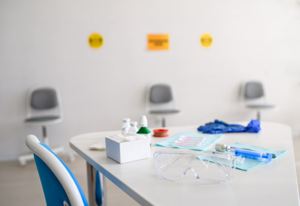 Syringes, protective glasses and other medical equipment on desk, coronavirus, covid-19 and vaccination concept.