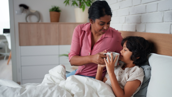 A mother taking care of her ill son at home.