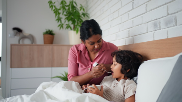 A mother taking care of her ill son at home.