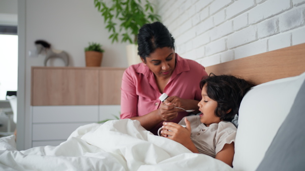 A mother taking care of her ill son at home.