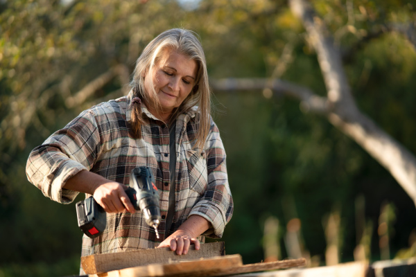 A handy female carpenter working in carpentry diy workshop outdoors