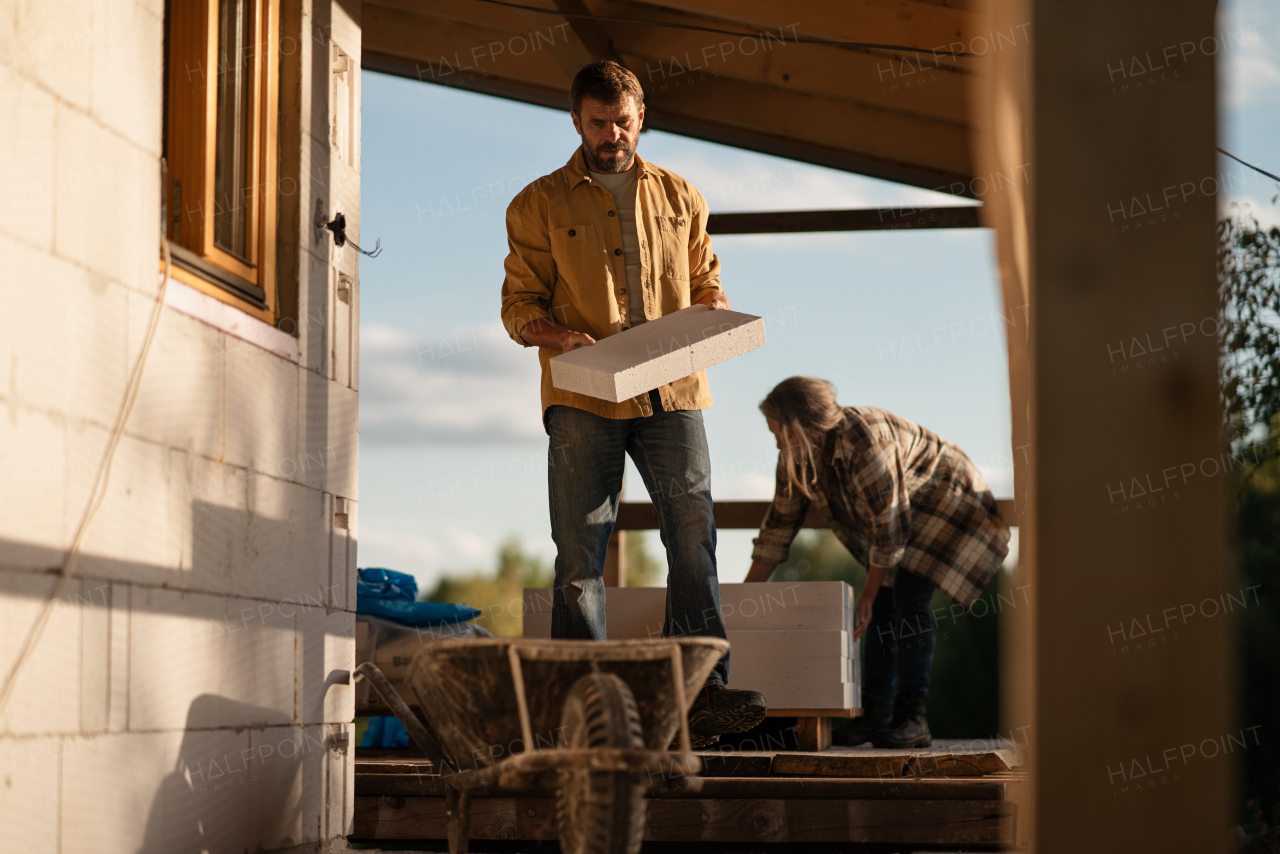 A mature man working on construction site of their new house.