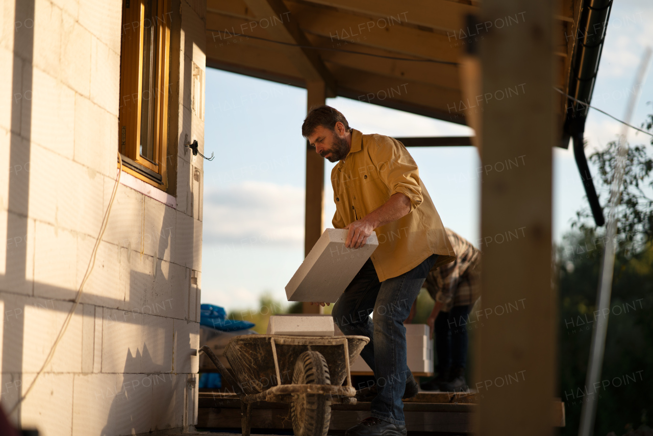 A mature man working on construction site of their new house.