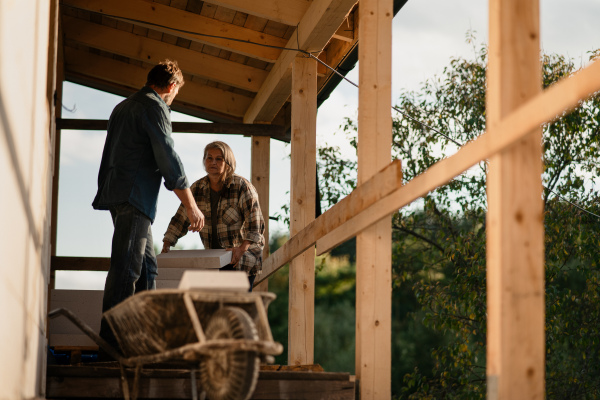 A mature couple working together on construction site of their new house.