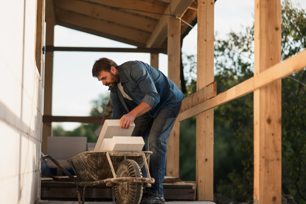 A mature man working on construction site of their new house.