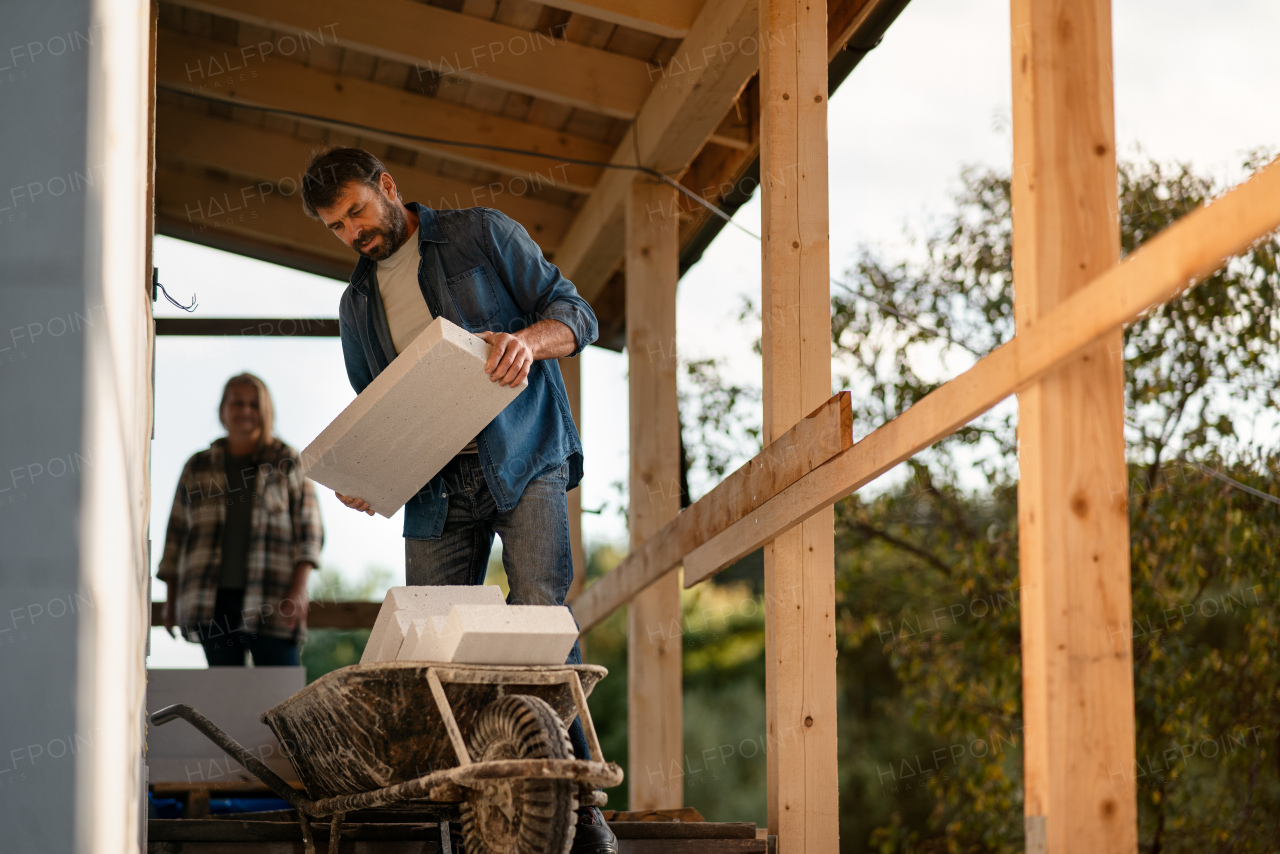 A mature couple working together on construction site of their new house.