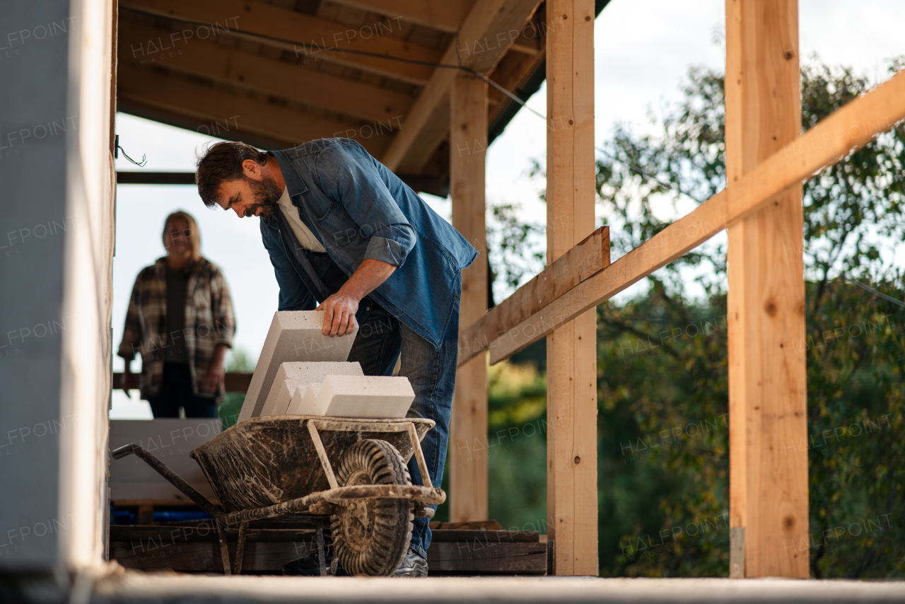 A mature couple working together on construction site of their new house.