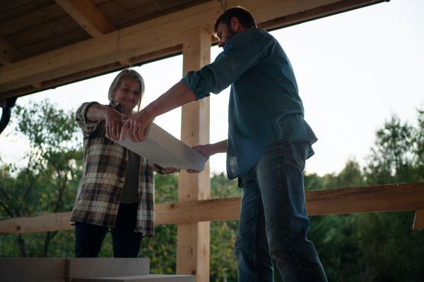 A mature couple working together on construction site of their new house.