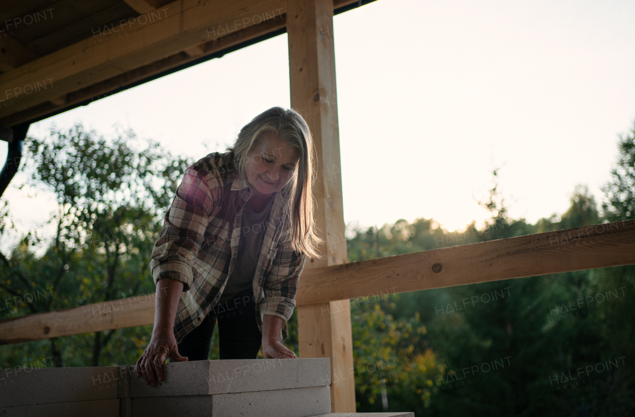 A mature woman working on construction site of their new house.