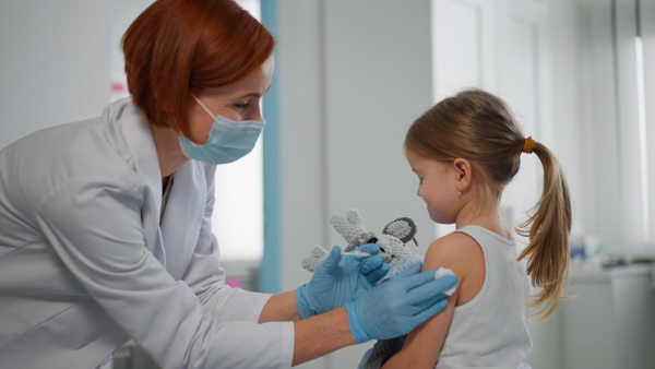 A worried little girl getting vaccinated in doctor's office.