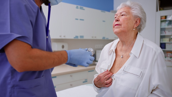 A close-up of unrecognizable senior woman being checked with stethoscope by her doctor in doctor's office.