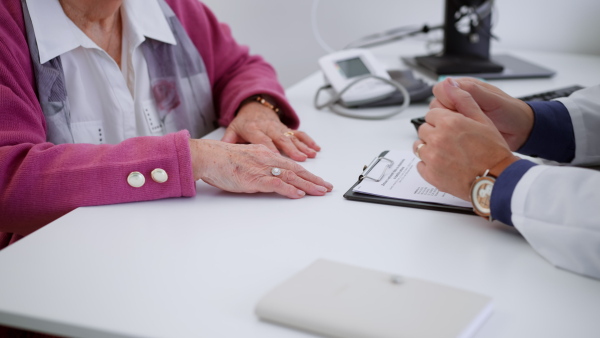 A close-up of senior woman on consultation with doctor in his office.