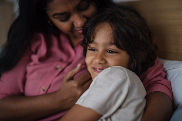 A close-up of indian mother hugging her little son at home.