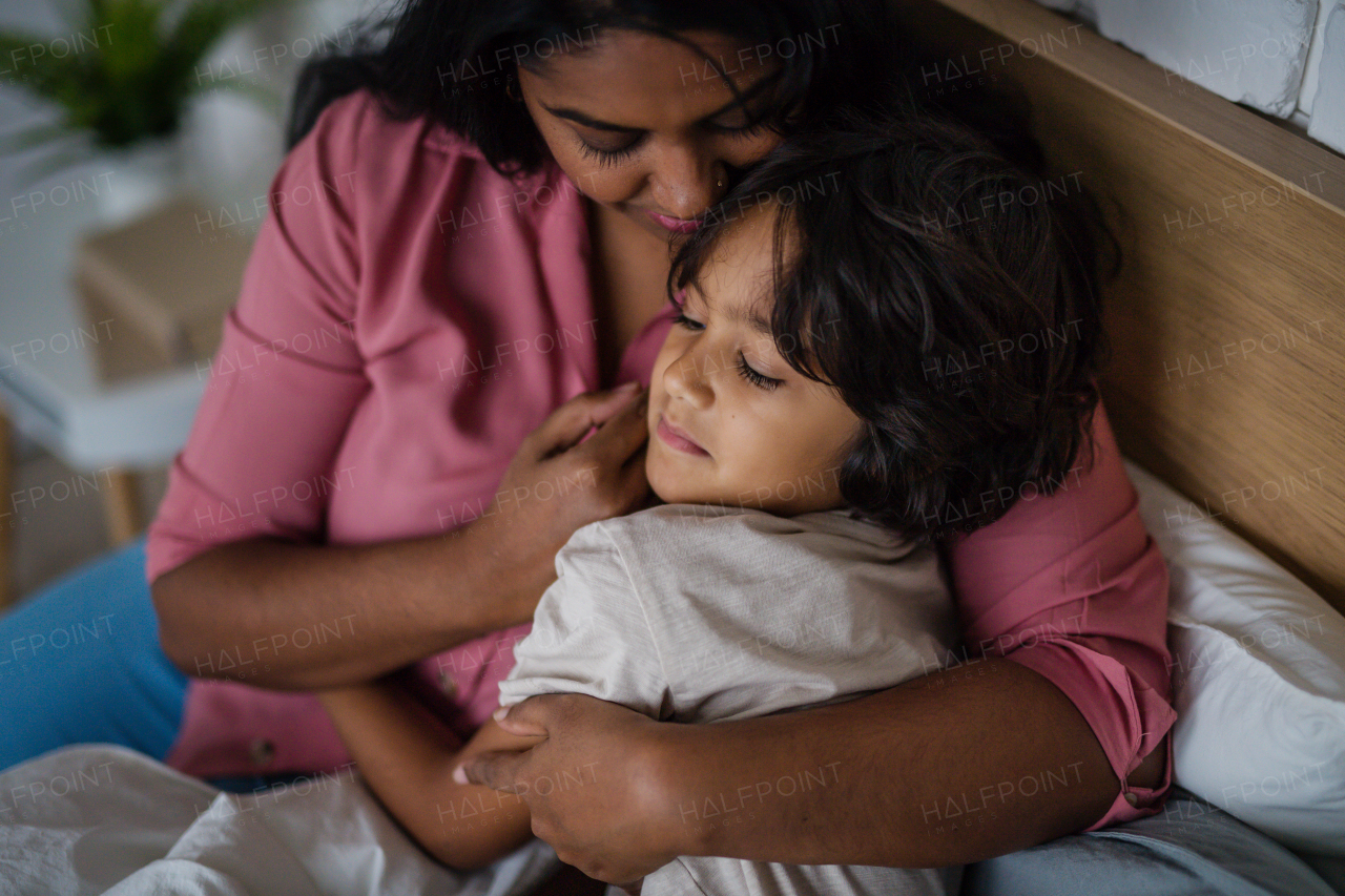 A close-up of indian mother hugging her little son at home.