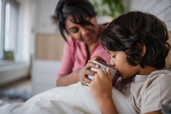 A mother taking care of her ill son at home.