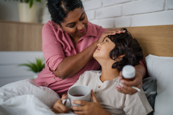 A mother taking care of her sick son at home.