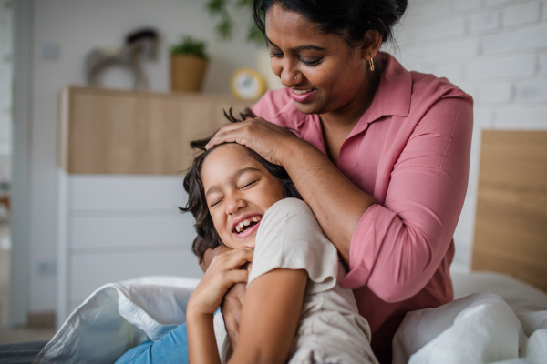 An Indian mother hugging her little son and having fun at home.