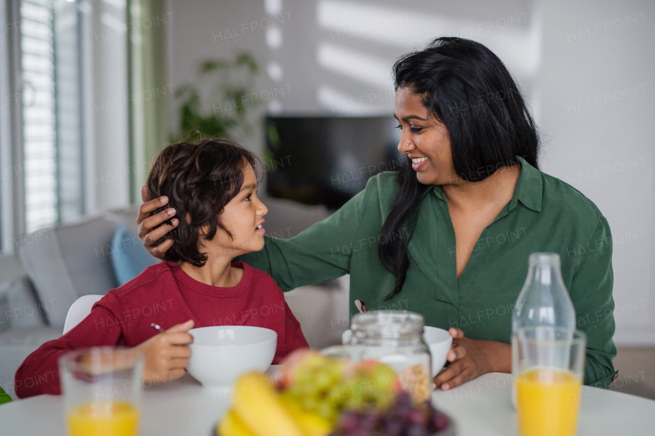 A little boy having breakfast with his mother at home.