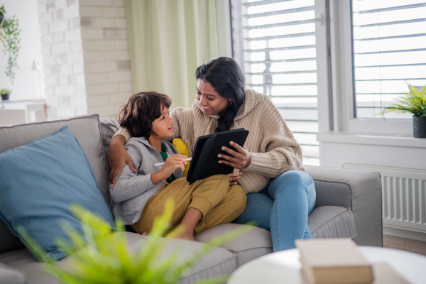 An Indian mother using tablet with her little son and having fun at home.