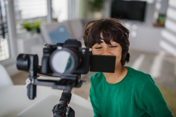 A happy multiracial boy cameraman amateur at home.