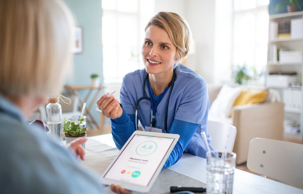 Nurse, caregiver or healthcare worker with senior woman patient, measuring blood glucose indoors.