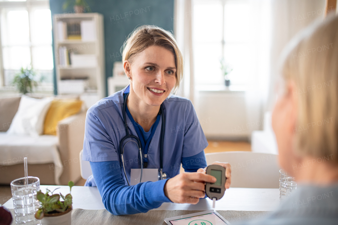 Nurse, caregiver or healthcare worker with senior woman patient, measuring blood glucose indoors.