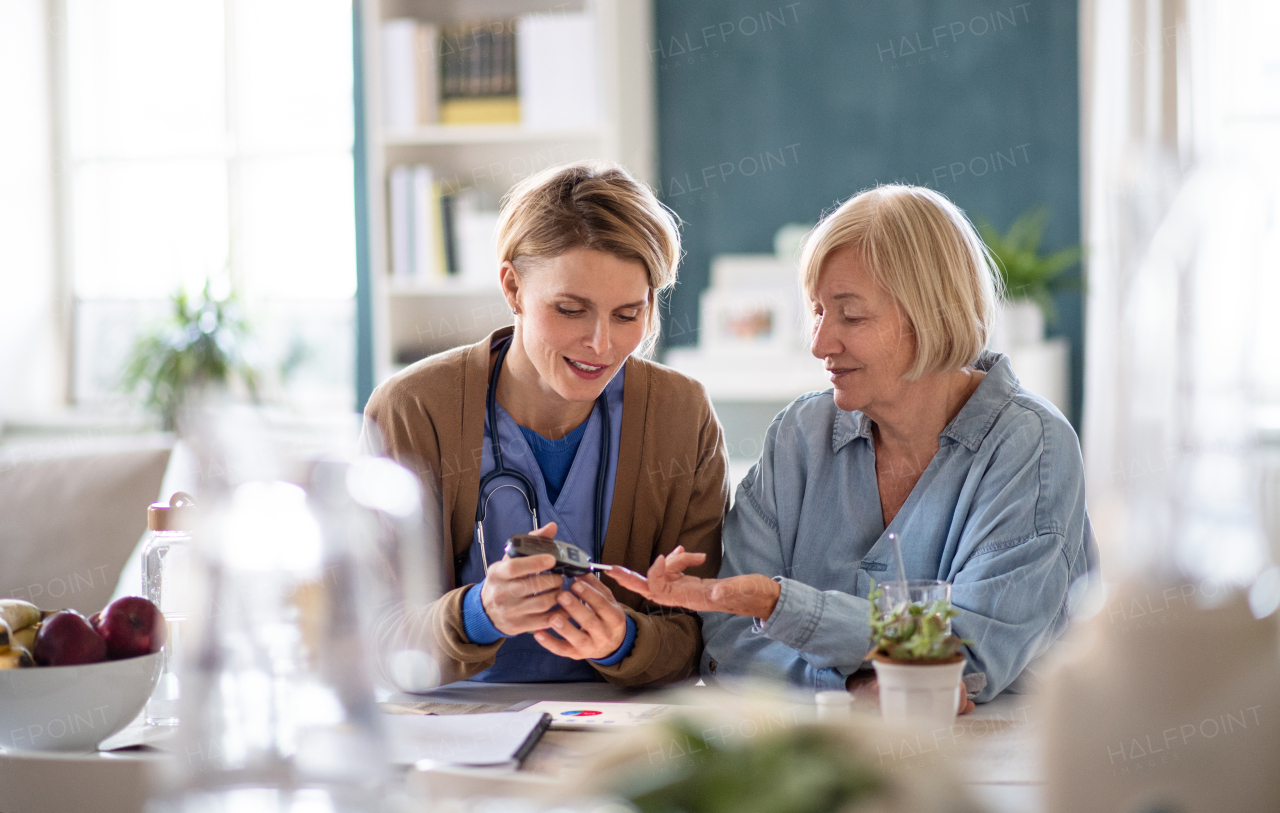 Nurse, caregiver or healthcare worker with senior woman patient, measuring blood glucose indoors.